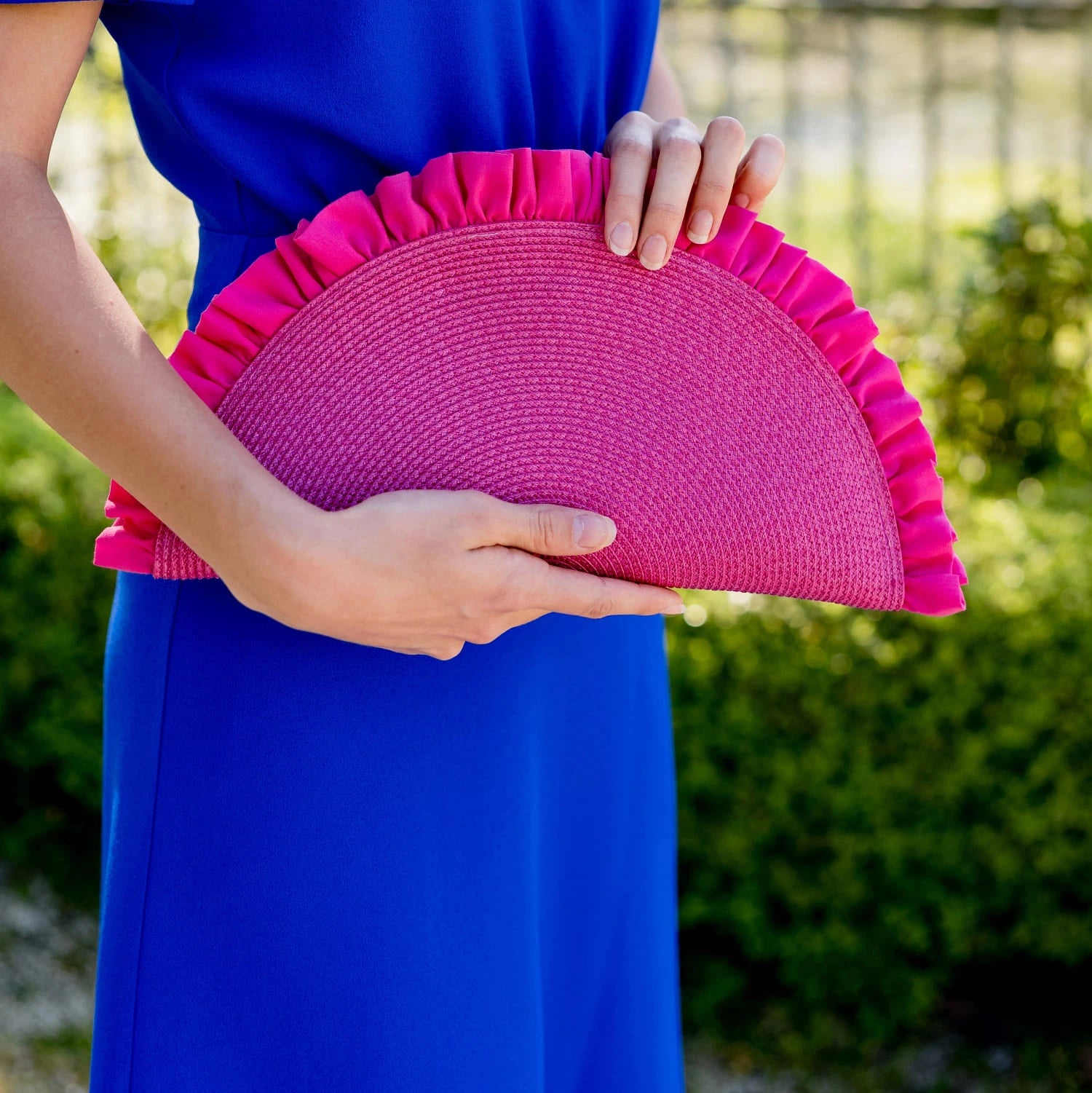 Pochette rose mise en avant dans les mains d'une jeune femme. Création de la nouvelle collection Bellemond.