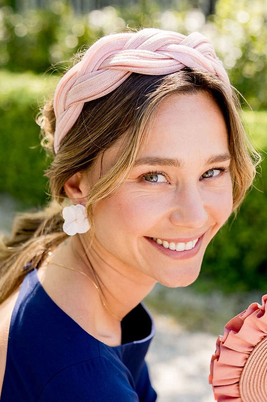 Jeune femme avec des boucles d'oreilles roses poudrés en hortensia stabilisé. Créé par Bellemond.