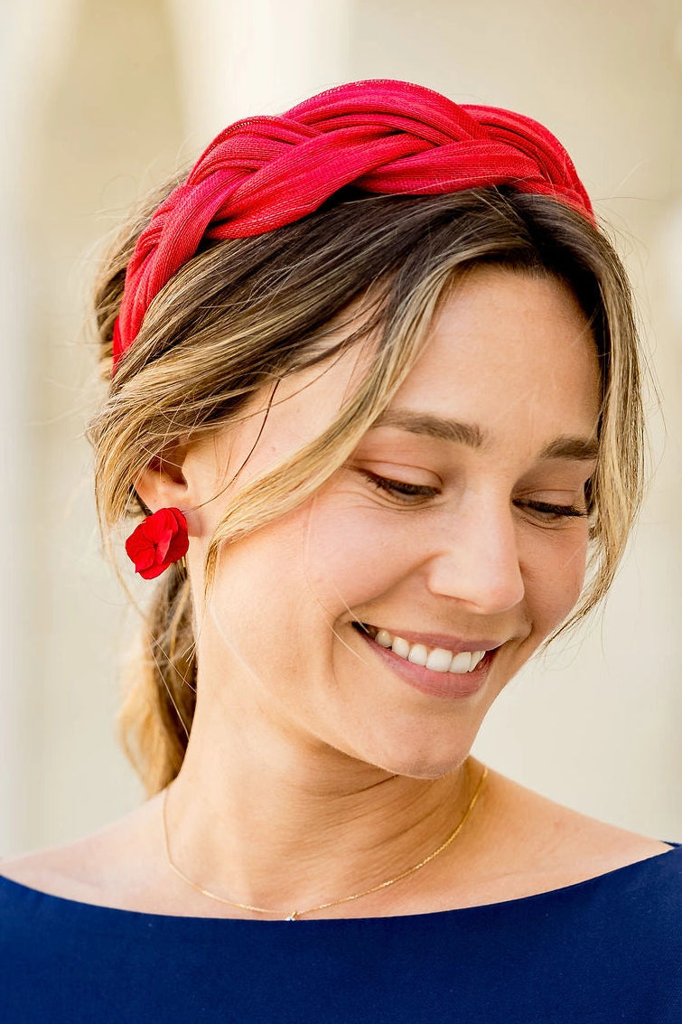Jeune femme habillée de bleu avec des boucles d'oreilles en hortensia stabilisé de couleur rouges. Créé par Bellemond.