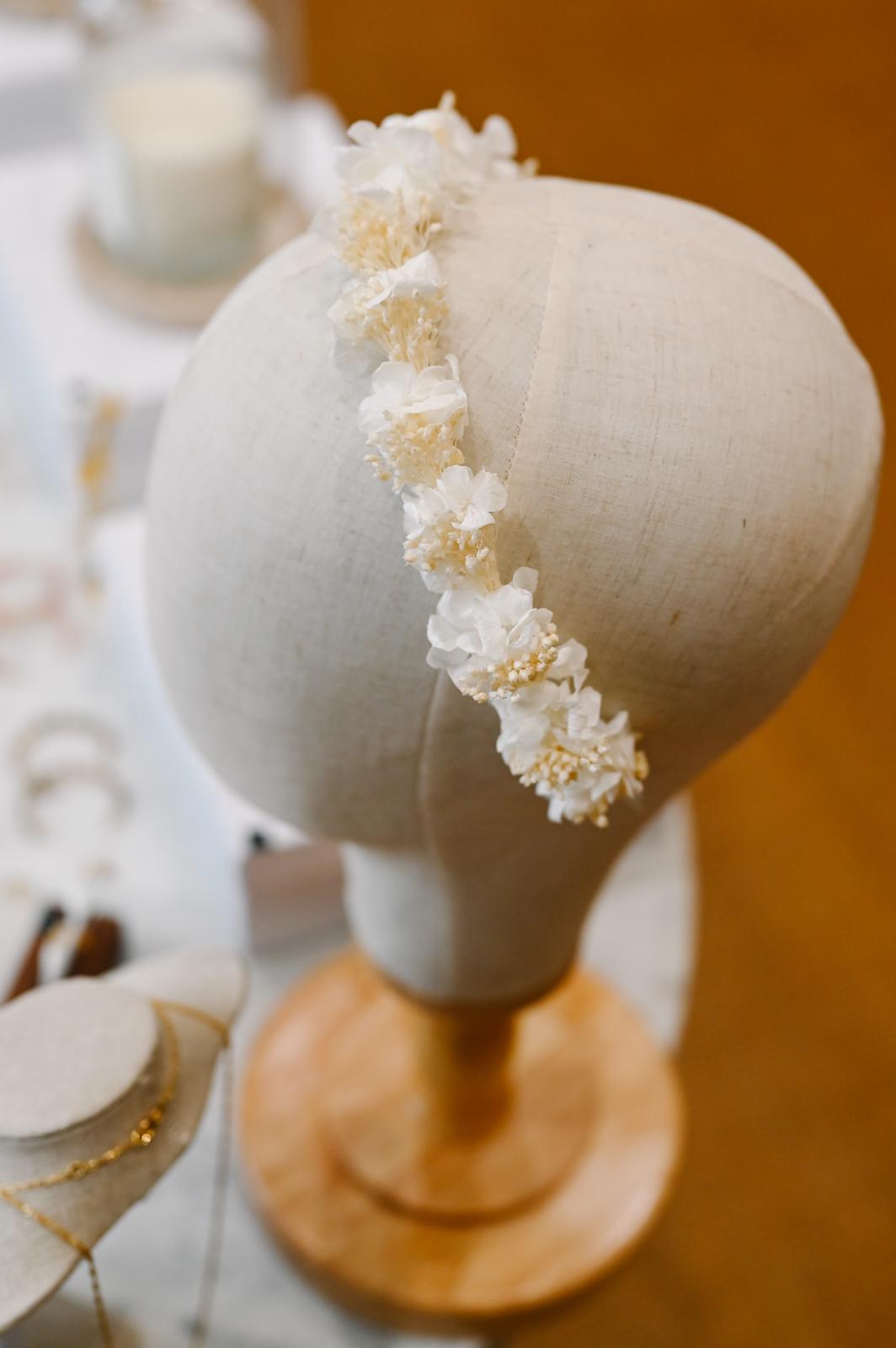 Couronne de fleurs Thaïs Couronne pour enfant en fleurs séchées et stabilisées : hortensias et broom. D’une grande douceur, cette couronne apportera une touche de couleurs et un bel effet à votre cortège. Idéale pour les petites demoiselles d'honneur. Création Bellemond