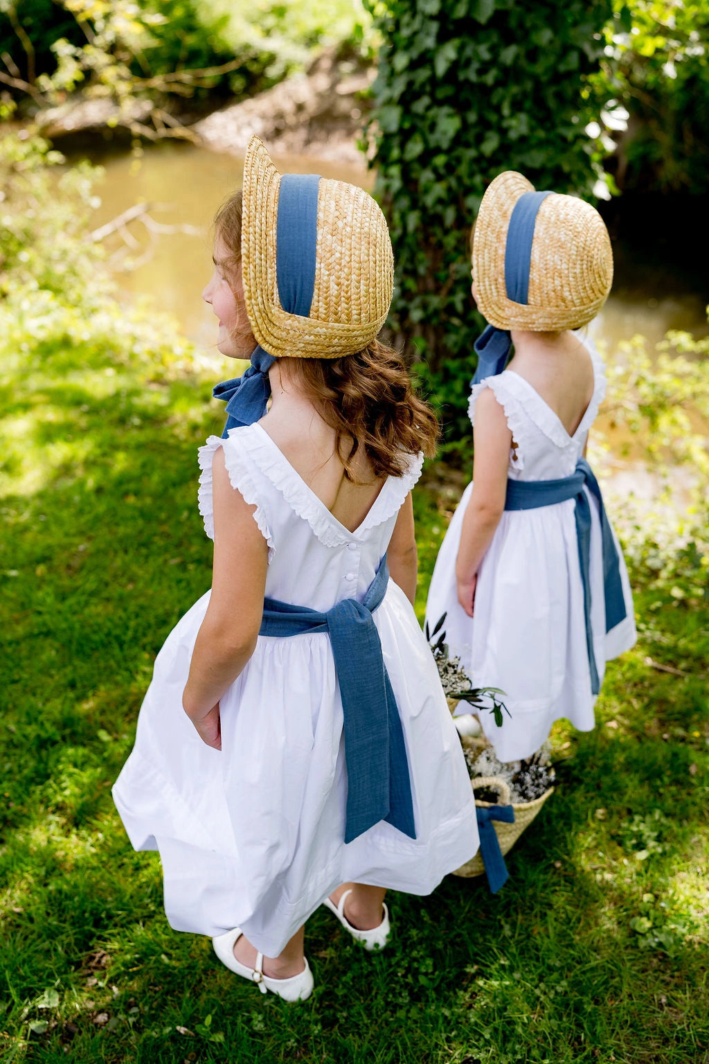 Deux filles portant des petits chapeaux en paille de type calotte ou creusois avec ruban en gaze de coton bleu gris. Créé par Bellemond.