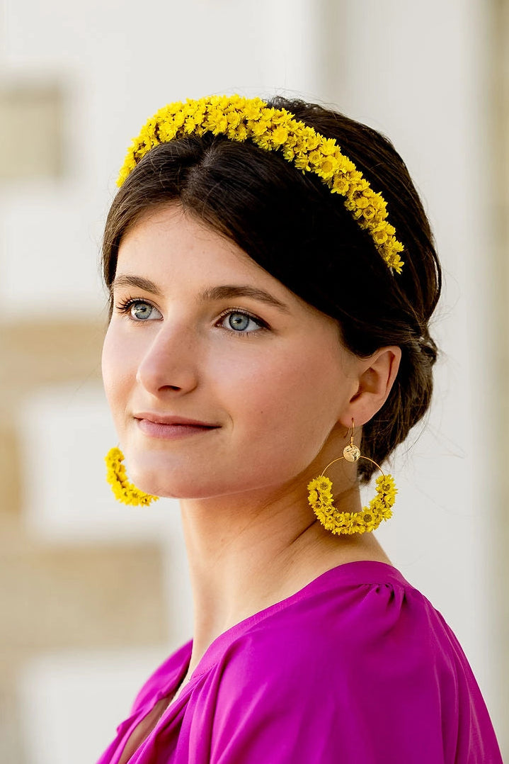 Jeune femme portant des boucles d'oreilles jaunes en glixia séchées créé par Bellemond.