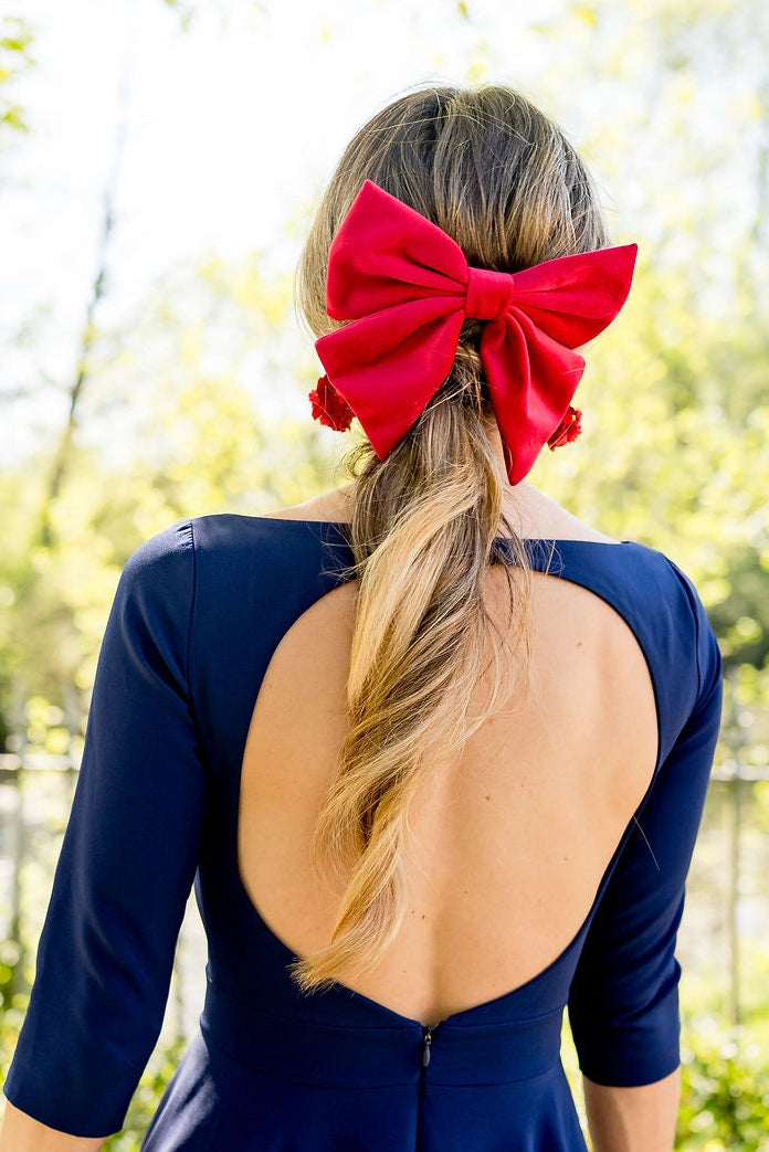 Femme en robe bleue avec dans les cheveux une barrette rouge sous forme de noeud en velours. Créé par Bellemond.