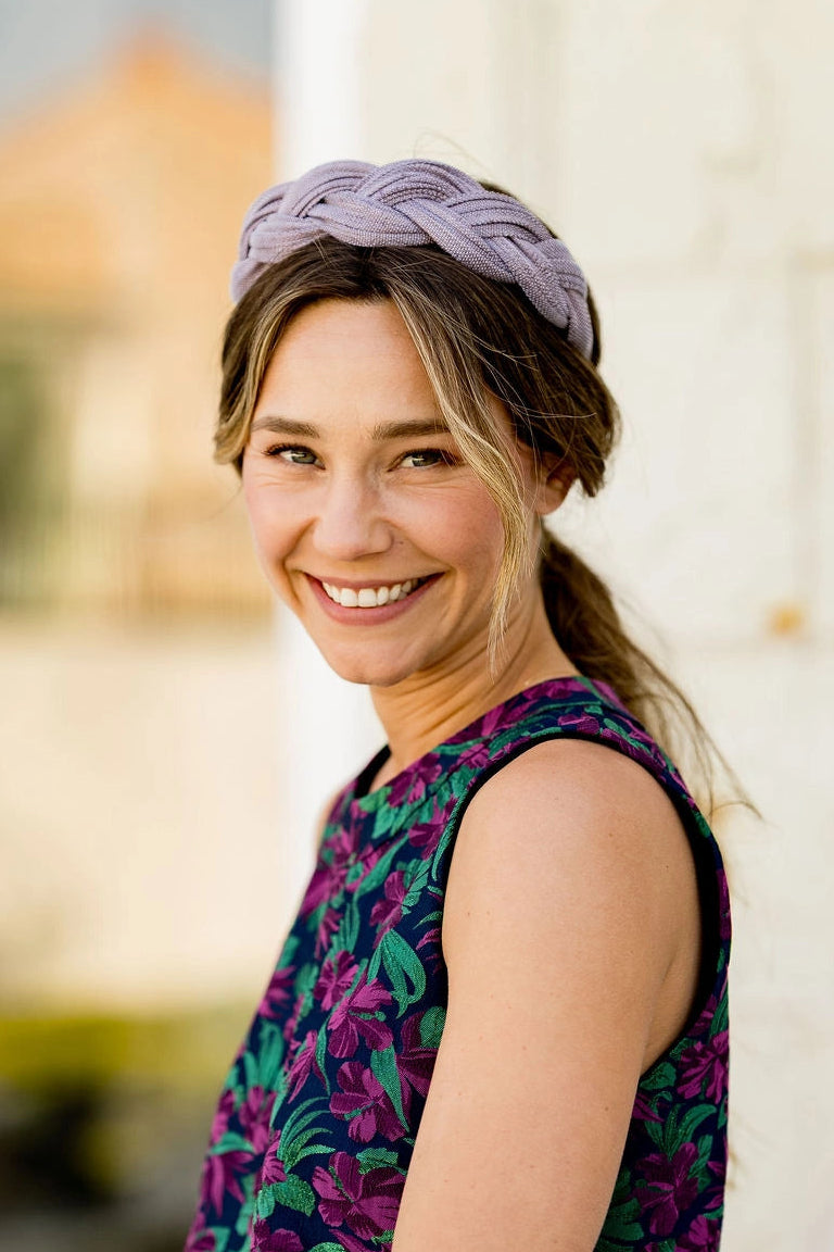 Jeune femme avec un top multicolore portant un serre-tête tressé en sinamay dans les cheveux. Créé par Bellemond.