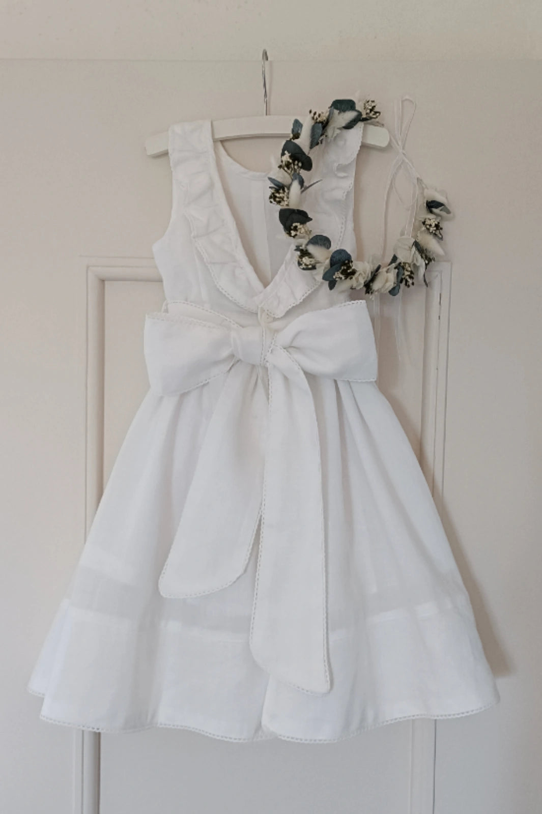 Petite robe de cérémonie blanche avec couronne de fleurs pour enfant dans les tons verts et blancs. Créé par Bellemond.