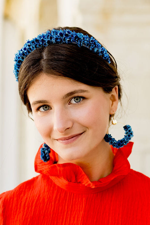 Jeune femme portant des boucles d'oreilles en glixia séchées bleues créé par Bellemond.
