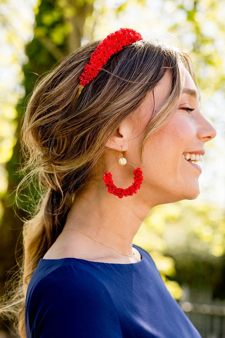 Jeune femme portant des boucles d'oreilles en glixia séchées rouges créé par Bellemond.