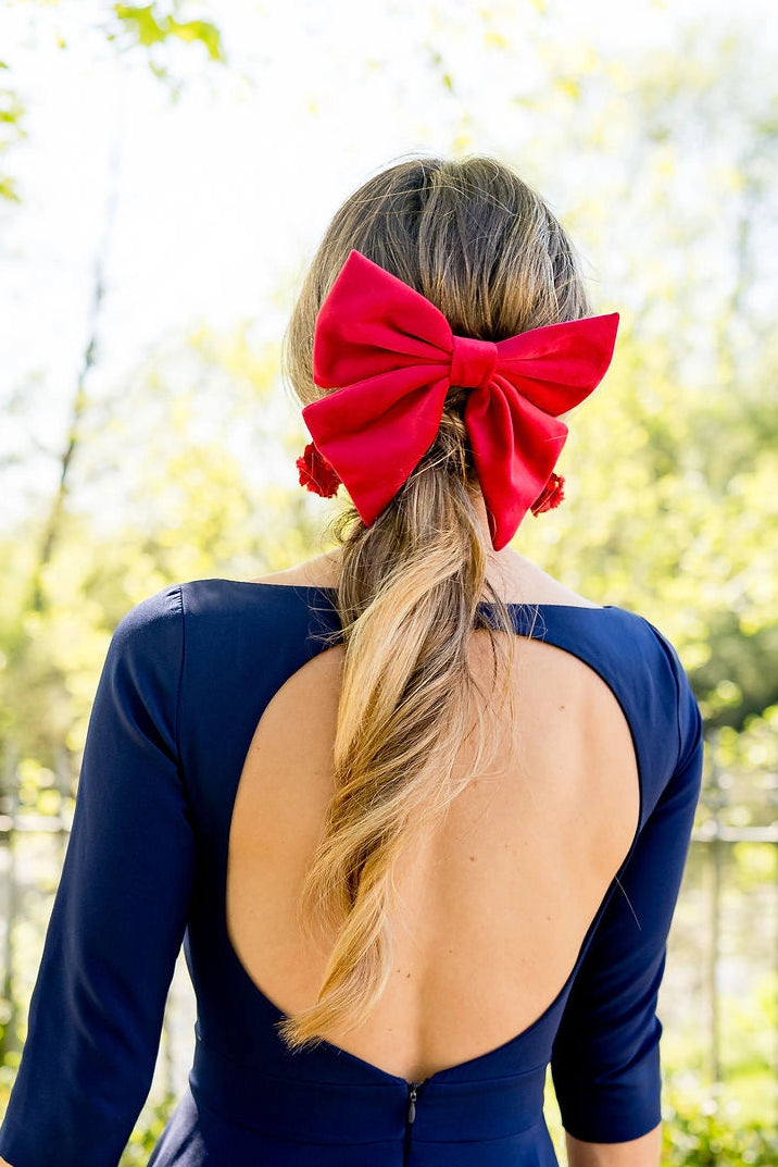Jeune femme habillée d'une robe bleue marine ayant dans les cheveux une barrette en forme de noeud en velours de couleur rouge. Créé par Bellemond.