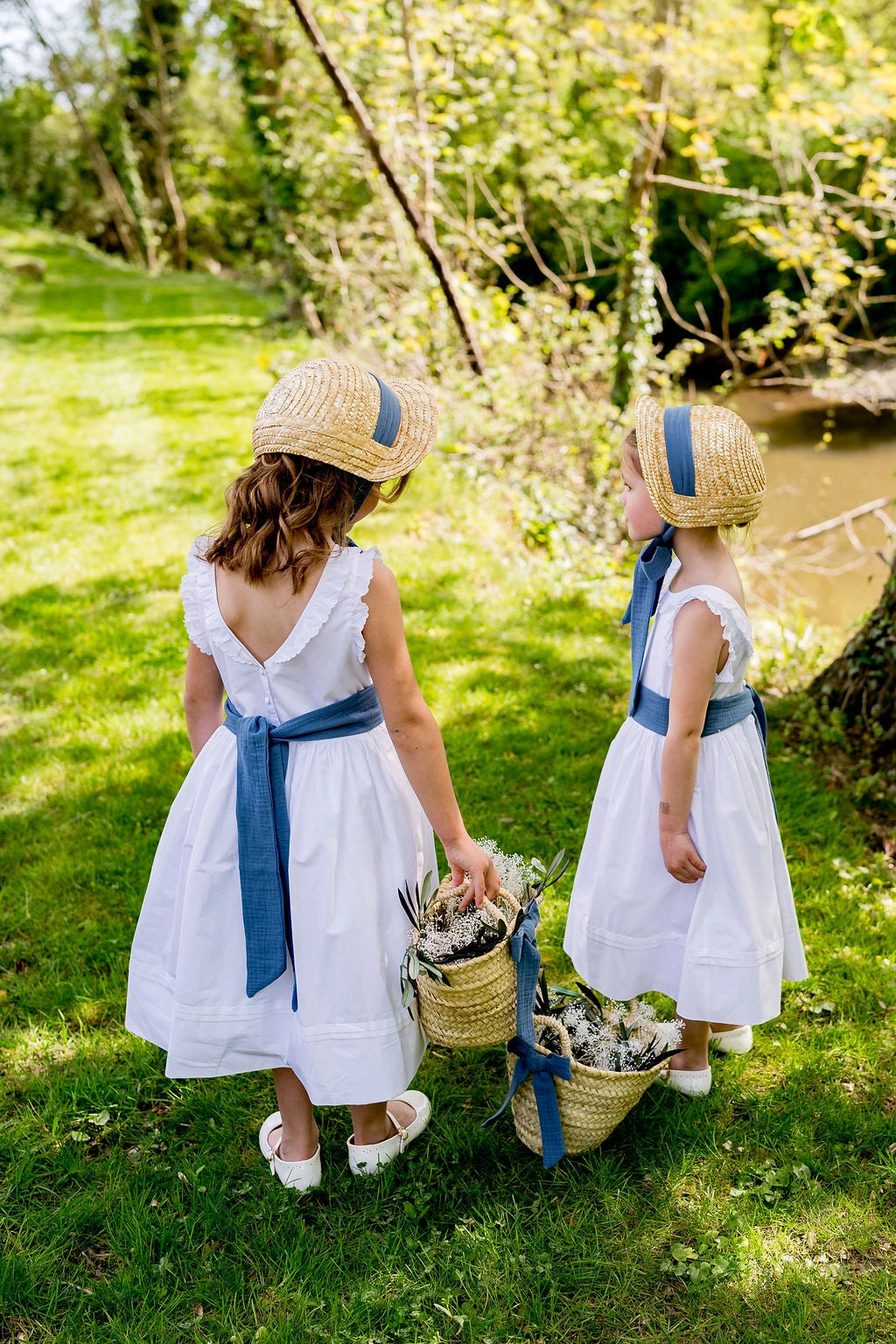 Enfants d'honneur avec petits paniers en doum et petits chapeaux de paille dans un cadre verdoyant. Créé par Bellemond.