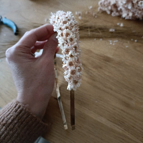 Image d'une main qui tient un serre-tête avec les décorations en arrière plan - Image représentant l'artisanat