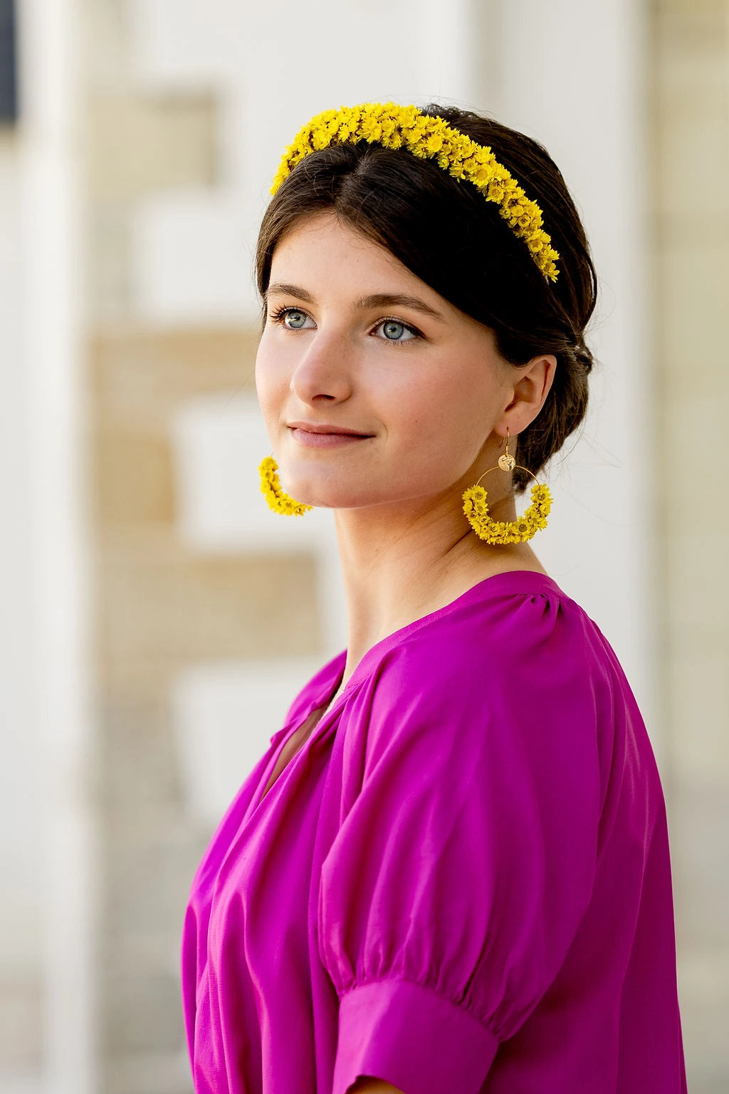 Jeune femme habillée d'une robe fuchsia portant dans les cheveux un serre-tête composé de glixia jaunes. Céé par Bellemond.