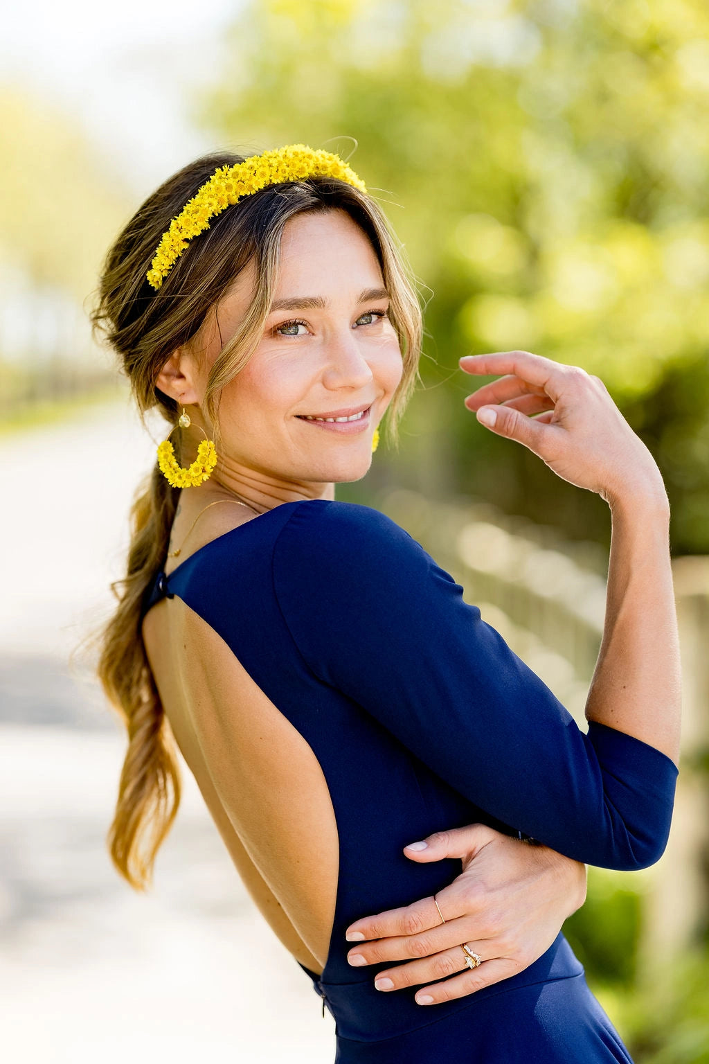 Jeune femme habillée d'une robe bleue marine portant dans les cheveux un serre-tête composé de fleurs glixia jaunes. Créé par Bellemond.